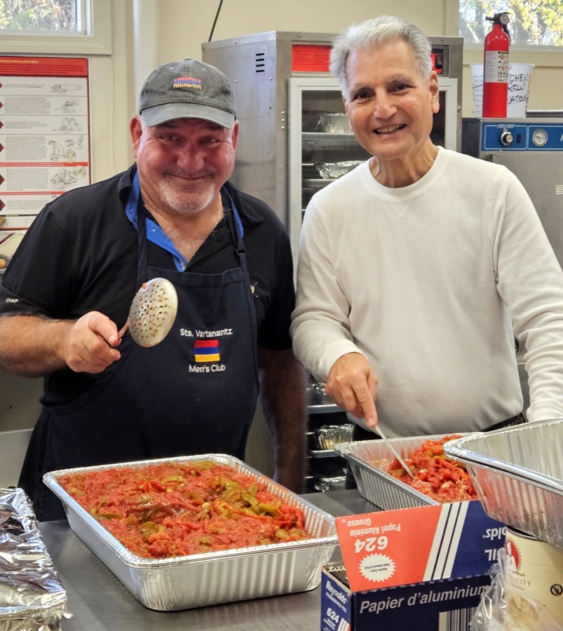The kitchen crew smiling over trays of food